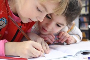 two small children working with pencil and paper